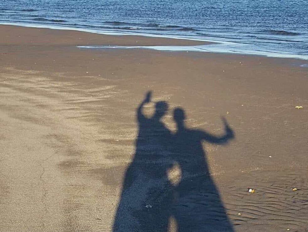 Shadows of people on the sand at the beach